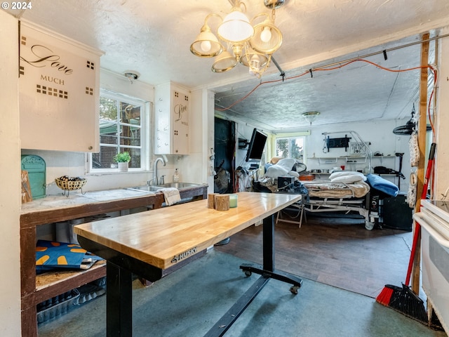 dining area featuring concrete floors, sink, and a chandelier