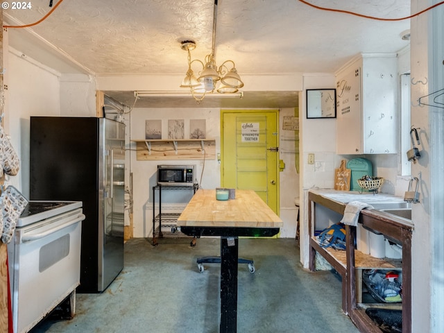 kitchen featuring a chandelier, appliances with stainless steel finishes, decorative light fixtures, and carpet flooring