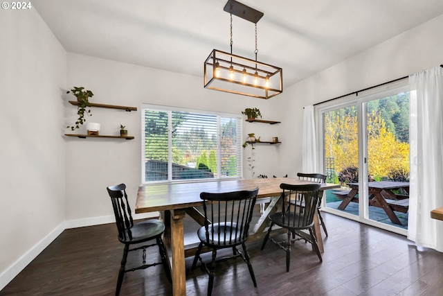 dining area featuring dark wood-type flooring and a chandelier