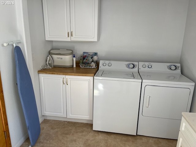 laundry room featuring separate washer and dryer and cabinets