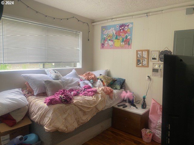 bedroom featuring a textured ceiling and wood-type flooring