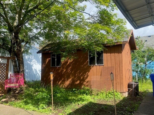 view of side of property with central air condition unit and a storage unit