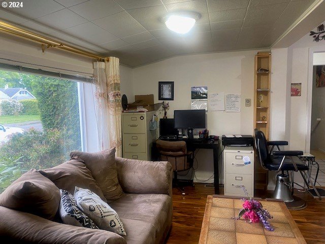 home office with dark hardwood / wood-style floors and vaulted ceiling