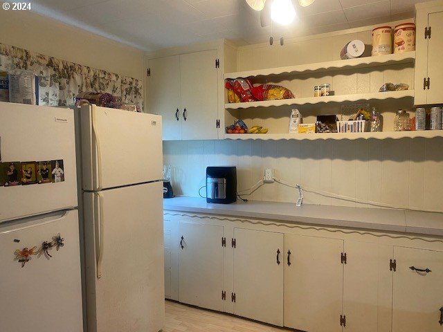 kitchen featuring white cabinetry, light wood-type flooring, and white refrigerator