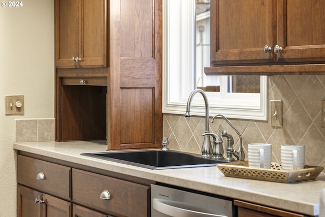 kitchen with dishwasher, tasteful backsplash, and sink