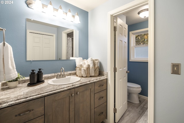 bathroom featuring hardwood / wood-style floors, vanity, and toilet