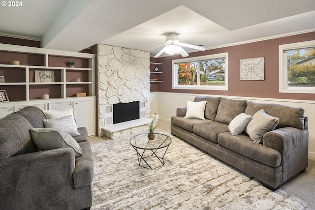 carpeted living room with crown molding, a fireplace, ceiling fan, and a textured ceiling