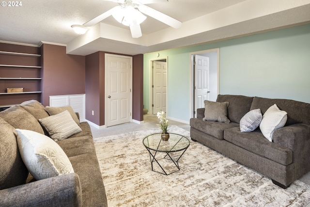 living room featuring light carpet, ceiling fan, and a textured ceiling