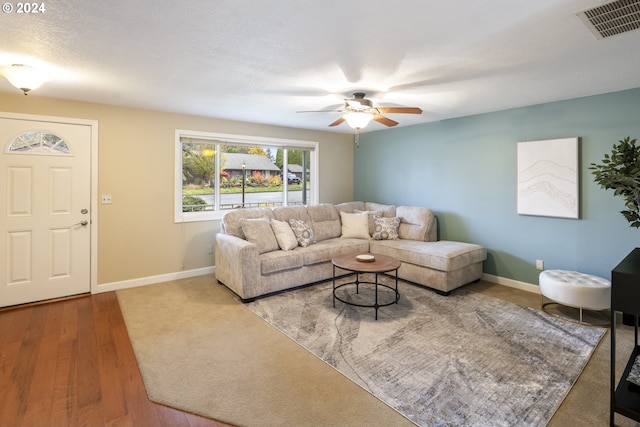 living room with hardwood / wood-style floors, a textured ceiling, and ceiling fan