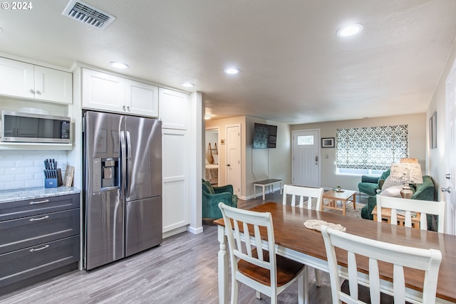 kitchen featuring light wood finished floors, white cabinetry, visible vents, and appliances with stainless steel finishes