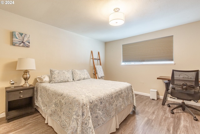 bedroom featuring baseboards and wood finished floors