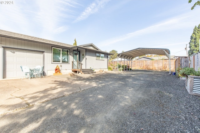 ranch-style home with fence, entry steps, a garage, driveway, and a detached carport