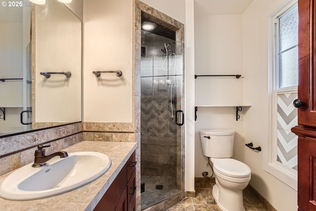 bathroom with vanity, toilet, and a shower with door