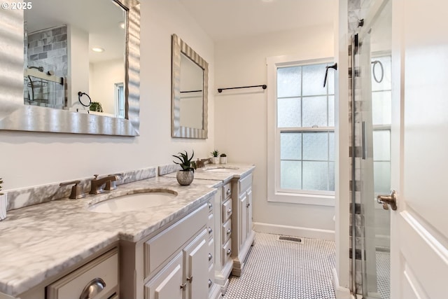 bathroom featuring tile patterned floors, plenty of natural light, walk in shower, and vanity