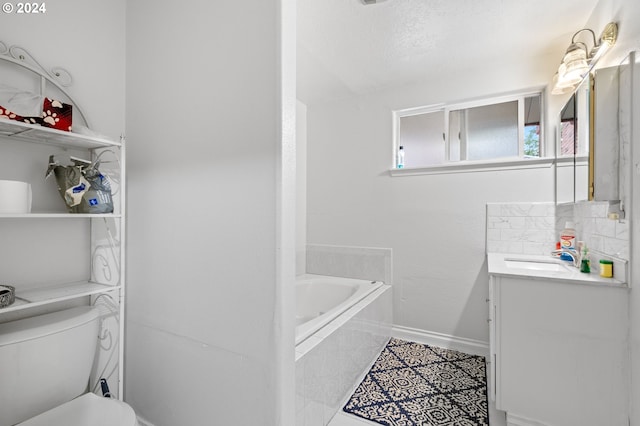 bathroom with tile patterned flooring, a textured ceiling, tiled bath, toilet, and vanity