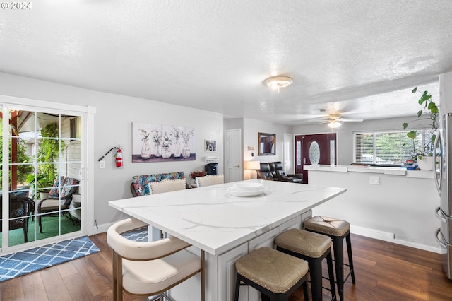 interior space featuring dark hardwood / wood-style floors, a textured ceiling, and ceiling fan