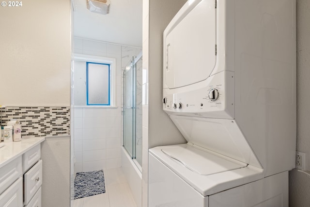 laundry room featuring stacked washer / dryer and light tile patterned floors