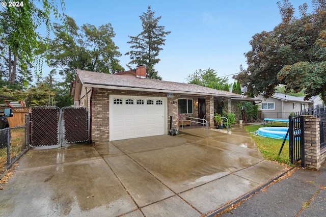 view of front of home with a garage and a swimming pool