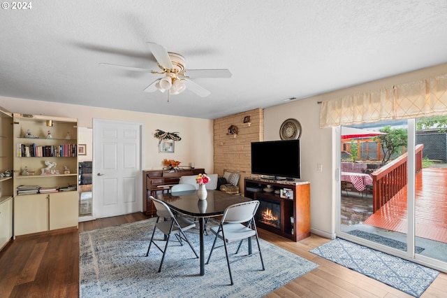 dining room featuring ceiling fan, a textured ceiling, and hardwood / wood-style flooring