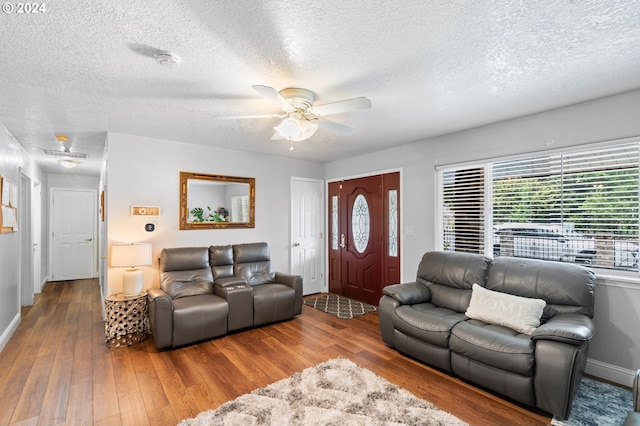 living room featuring a textured ceiling, ceiling fan, and wood-type flooring