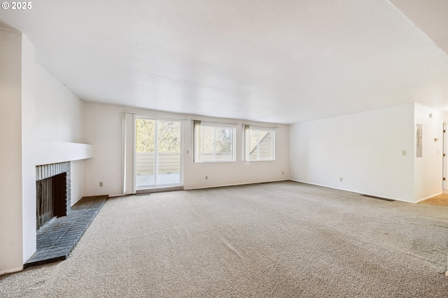 unfurnished living room with a brick fireplace and carpet