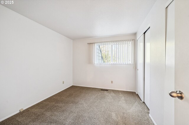 unfurnished bedroom featuring carpet and a closet