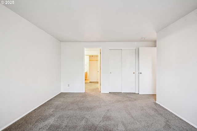 unfurnished bedroom featuring light carpet and a closet