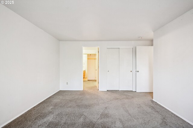 unfurnished bedroom with a closet and light carpet