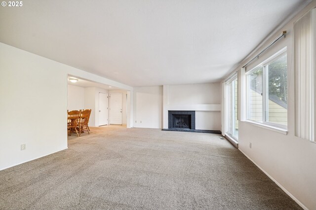 unfurnished living room with carpet and a fireplace