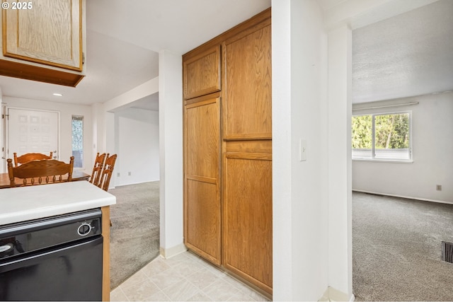 kitchen featuring light colored carpet and black dishwasher