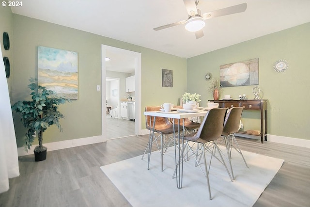 dining space with baseboards, a ceiling fan, and light wood-style floors