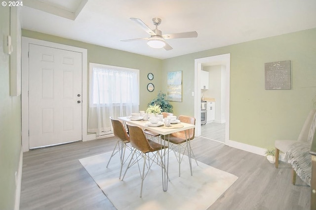 dining area with a ceiling fan, baseboards, and wood finished floors