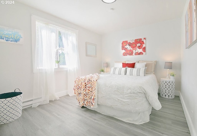 bedroom with baseboards and wood finished floors