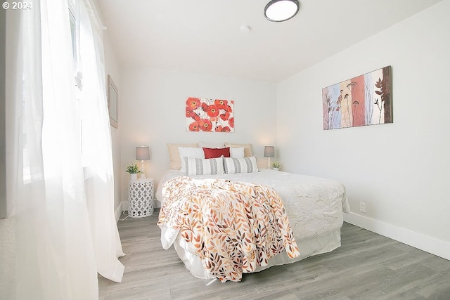 bedroom with wood finished floors and baseboards