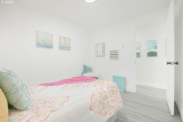 bedroom with light wood-style flooring and baseboards