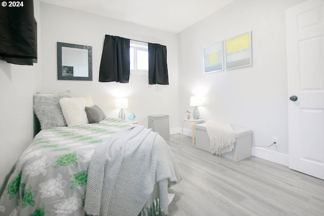 bedroom with light wood-type flooring and baseboards