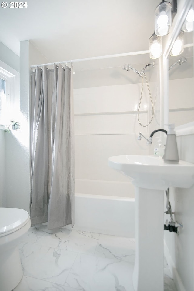 bathroom featuring marble finish floor, toilet, and shower / tub combo with curtain