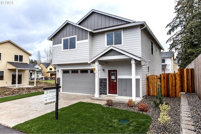 view of front facade featuring board and batten siding, fence, a garage, stone siding, and driveway