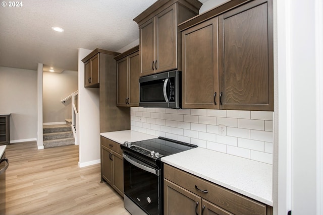 kitchen featuring light hardwood / wood-style flooring, a textured ceiling, tasteful backsplash, dark brown cabinetry, and stainless steel appliances