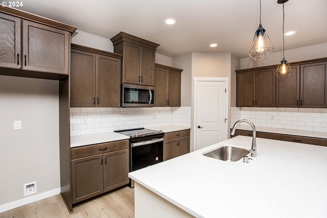 kitchen with electric range, sink, hanging light fixtures, tasteful backsplash, and light wood-type flooring