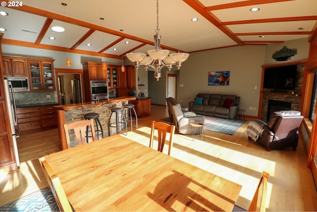 dining area with lofted ceiling with beams and light hardwood / wood-style floors