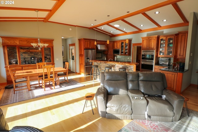 living room with light wood-type flooring and high vaulted ceiling