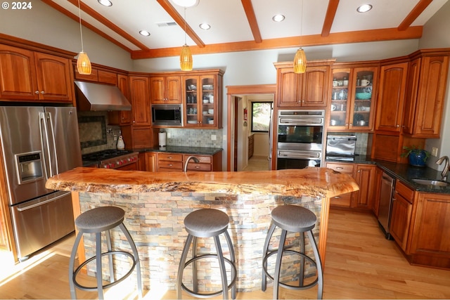 kitchen featuring stainless steel appliances, lofted ceiling with beams, backsplash, extractor fan, and a breakfast bar