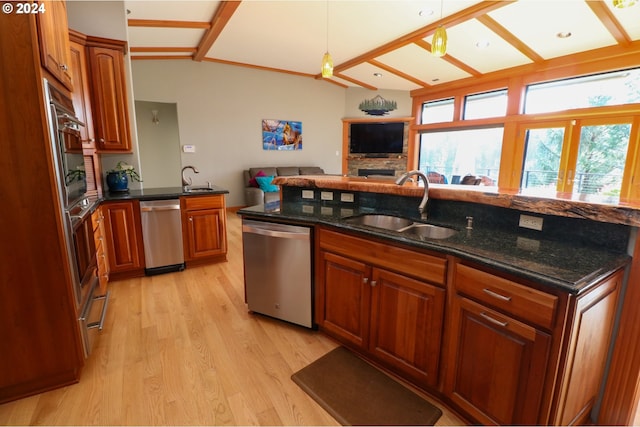 kitchen featuring sink, stainless steel dishwasher, vaulted ceiling with beams, dark stone countertops, and light wood-type flooring