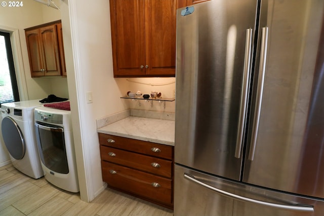 laundry area featuring separate washer and dryer, cabinets, and light wood-type flooring