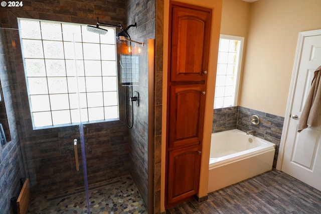 bathroom with independent shower and bath and hardwood / wood-style floors