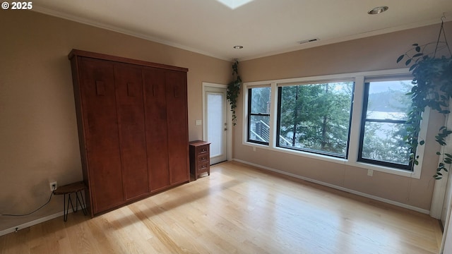 unfurnished bedroom with crown molding and light hardwood / wood-style floors