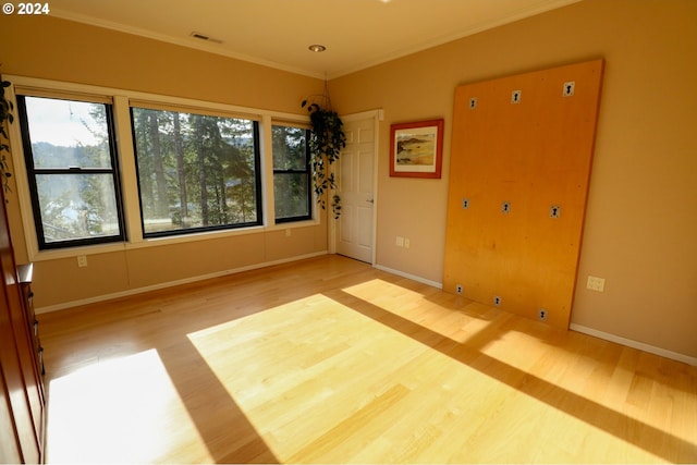 unfurnished room featuring wood-type flooring and crown molding