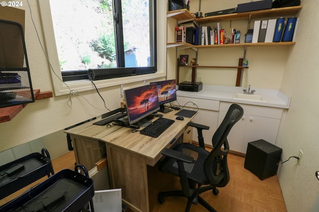 home office with light parquet flooring and sink