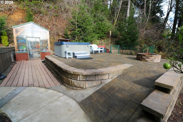 exterior space featuring an outdoor fire pit, an outdoor structure, and a hot tub